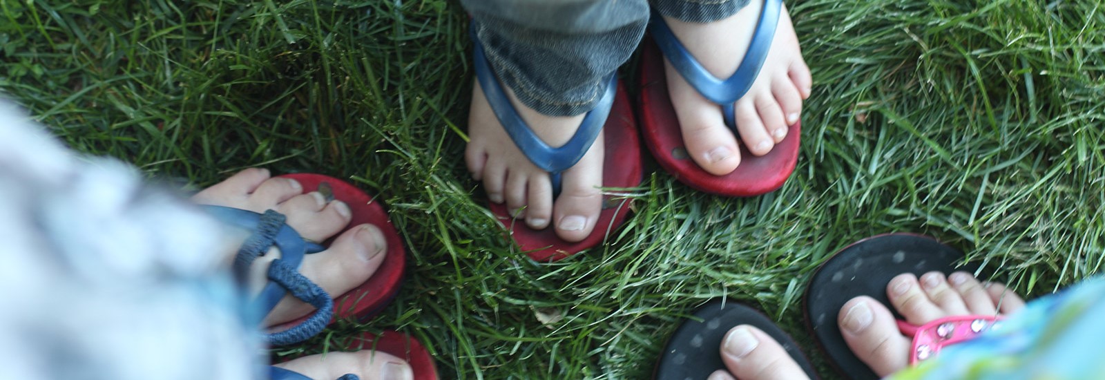 Photo of 3 pairs of kids feet.