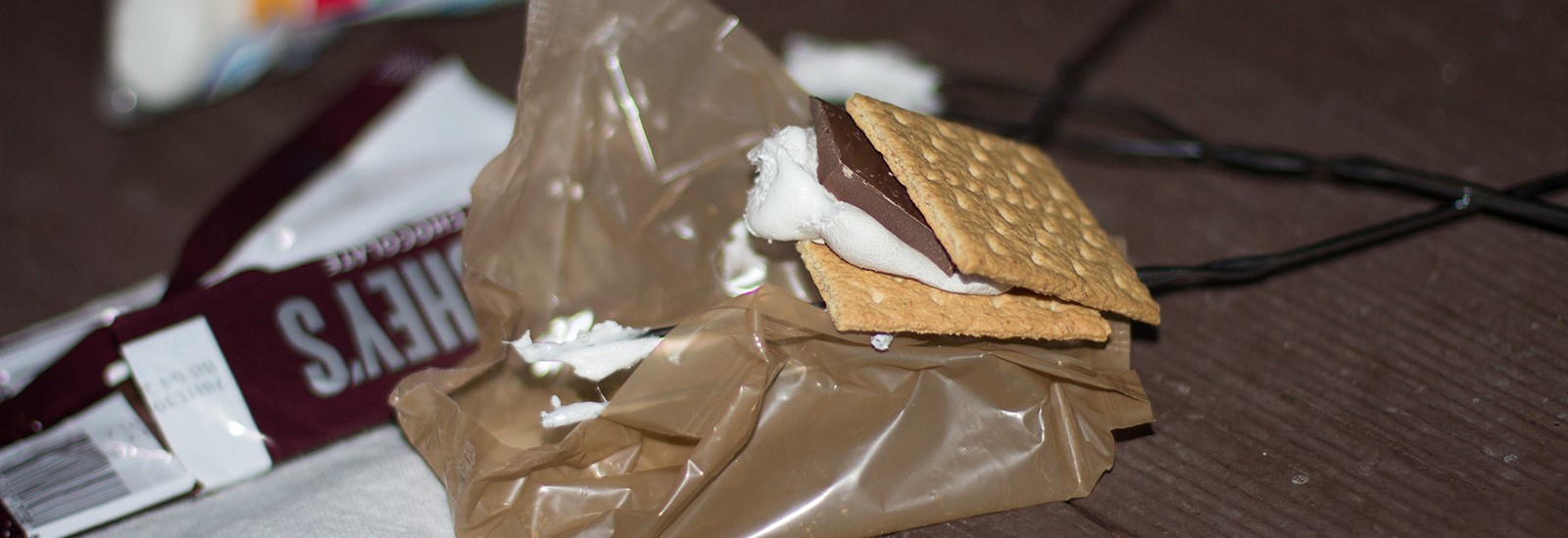 Photo of S'mores on a picnic table at night