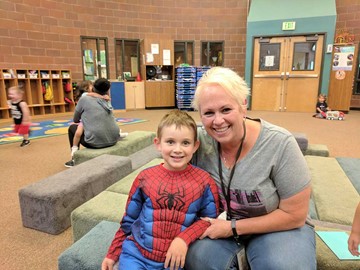 Small in a spider-man costume  with his teacher