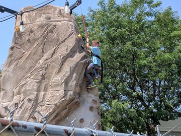 Medium going up a rock climbing wall